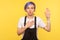 Portrait of honest serious hipster girl swearing with hand on her heart chest, making promise. yellow background, studio shot