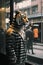 Portrait of a hooded Tiger dressed in clothes and standing alone on a rainy street in the middle of the city.