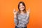 Portrait of hopeful joyous young woman with brown hair in long sleeve shirt. indoor studio shot isolated on orange background