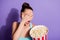 Portrait of horrified girl hold big pop corn box watch horror series afraid close cover hand face wear tank-top isolated