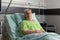 Portrait of hospitalized retired sick woman looking into camera resting in bed