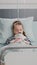 Portrait of hospitalized sick child falling asleep while holding teddy bear in hands