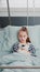 Portrait of hospitalized sick girl child patient holding teddy bear resting in bed during medical consultation