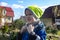 Portrait of a hot and stuffy child dressed in a jacket and a hat on a summer day against the backdrop of a bright