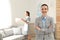 Portrait of housekeeping manager and blurred maid in room. Space for text