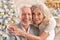 Portrait of a hugging senior couple with blurred Christmas decorations