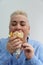 Portrait of hungry adult woman with short hair eating traditional Greek gyros with closed eyes