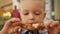 Portrait hungry blond 4-year-old boy sitting fast food and eating fried chicken in breadcrumbs. Caucasian kid satisfies