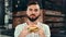 Portrait of hungry stylish man biting fresh appetizing burger looking at camera medium close-up
