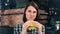 Portrait of hungry teenage smiling woman eating fast food looking at camera medium close-up