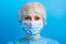 Portrait of ill woman wearing medical uniform and mask with pandemic text at blue background. and health care concept