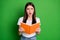 Portrait of impressed pretty brunette hair girl hold book wear white t-shirt isolated on green color background