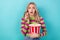 Portrait of impressed speechless girl with wavy hairdo wear stylish clothes hold popcorn at cinema isolated on blue