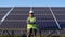 Portrait of indian asian electrician engineer in safety helmet and uniform near solar panels