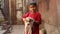 Portrait of Indian boy on a street in Mumbai holding a puppy.