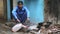 Portrait of Indian man filling container with water on the street.