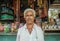 Portrait of indian man standing past rural store with food and water