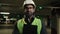 Portrait Indian man worker contractor mechanic guy in helmet and glasses posing with clipboard folder indoors parking