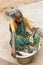 Portrait of an Indian old senior poor very thin woman with saree, selling fish