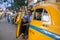 Portrait of an indian taxi driver with his antique oldtimer yellow taxi on the streets of Kolkata