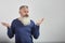 Portrait of indignant mature gray-haired bearded man on gray background, selective focus