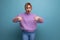 portrait of an indignant sad blonde young woman in a lavender sweater on a bright plain background