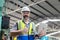 Portrait of industrial man man engineer wear uniform and helmet holding laptop show thumb up standing at factory. manager