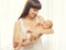 Portrait infant lying on hands of mother