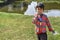 Portrait of An innocent poor boy of India standing on a ponds side and looking at camera, wearing the traditional dress