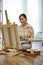 Portrait, Inspired Asian female artist painting with an acrylic color on her empty canvas easel