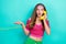 Portrait of interested adorable girl dressed pink top talking on landline phone look empty space  on teal color