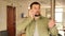 Portrait of interested young bearded man talking on phone while standing in building under renovation