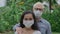 Portrait of an international couple in love, a European man and an Asian woman, wearing a face mask and looking directly