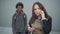 Portrait of irritated young Caucasian woman talking on the phone as blurred African American courier waiting at