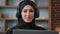 Portrait Islamic Muslim Arab woman in black hijab with laptop working online deadline typing late time overworked