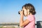 Portrait of a ittle girl taking photographs outdoors