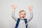 Portrait of a joyful blond schoolboy with a school bag. Hands up. White background