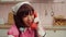 Portrait of joyful charming Asian female cosplayer talking on landline phone