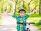 Portrait of a joyful child on a bicycle in a summer park