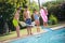 Portrait of joyful children standing on edge of swimming pool