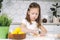 Portrait of Joyful concentrated little girl, sculpting dough shape biscuit, baking cup. Easter holiday event preparaton