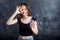 Portrait of joyful girl covering her eyes with donuts on black background. Attractive girl holding fresh donuts and having fun