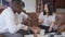 Portrait of joyful laughing Asian woman sitting with tea cup listening stories of African American men talking. Cheerful