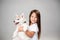 Portrait of a joyful little girl having fun with siberian husky puppy on the floor at studio