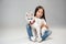 Portrait of a joyful little girl having fun with siberian husky puppy on the floor at studio