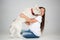 Portrait of a joyful little girl having fun with siberian husky puppy on the floor at studio