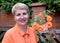 Portrait of the joyful woman of average years with roses against a brick protection