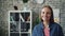 Portrait of joyful young lady smiling looking at camera standing in workplace