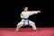 Portrait of a karate kid in kimono ready to fight isolated on black background