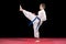 Portrait of a karate kid in kimono ready to fight isolated on black background